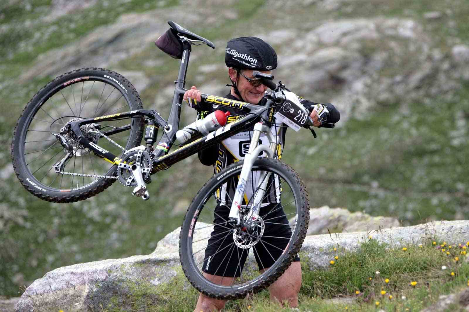 Beinnie Lindberg trägt sein MTB in den Bergen